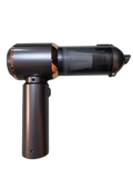 A compact black, grey, and copper cordless handheld vacuum with a sleek cylindrical design, shown upright with its main nozzle attached.