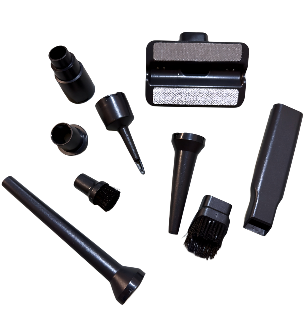 A set of multi-purpose vacuum attachments displayed next to the cordless handheld vacuum, including precision nozzles for tight spaces and vents.